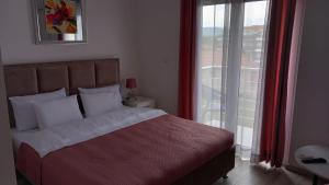 a bedroom with a bed and a sliding glass door at Lago d'argento sobe in Veliko Gradište