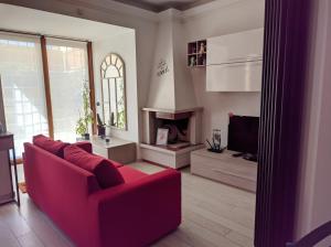 a living room with a red couch and a fireplace at La casetta gialla in Rome