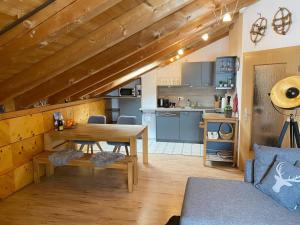 a living room with a wooden table and a kitchen at Edelweiss -229- in Mittenwald