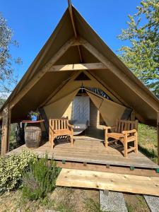 a gazebo with two chairs and a table at GLAMPING SUITE IL GRILLO in Lamporecchio
