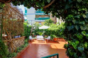 une terrasse avec une table, des chaises et un parasol dans l'établissement Garden House Giulia, à Sorrente