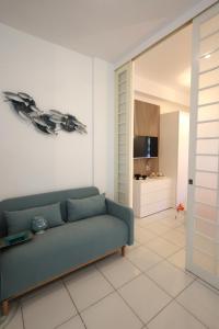 un salon avec un canapé bleu et une télévision dans l'établissement Garden House Giulia, à Sorrente