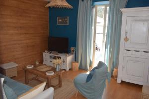 ein Wohnzimmer mit blauen Wänden und einem blauen Sofa in der Unterkunft Joli T3 centre de Briançon Serre-Chevalier, parking gratuit in Briançon