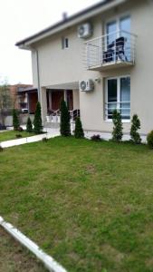 a white house with a lawn in front of it at Lago d'argento sobe in Veliko Gradište
