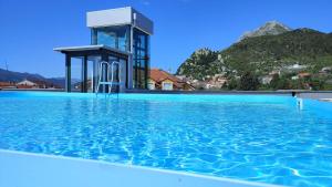 a swimming pool with a water tower in the background at Hotel Prvan in Vrgorac