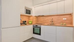a kitchen with white cabinets and a sink at Good Vibes in Zagreb