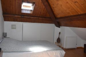 ein Schlafzimmer mit einem Bett und einer Holzdecke in der Unterkunft Joli T3 centre de Briançon Serre-Chevalier, parking gratuit in Briançon + 3 Fotos
