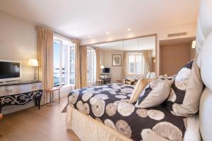 RARE! Appartement, 100m2, Climatisé - Port de Saint-Tropez في سانت تروبيز: غرفة نوم كبيرة بها سرير وتلفزيون