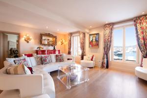 a living room with white furniture and a large window at RARE! Appartement, 100m2, Climatisé - Port de Saint-Tropez in Saint-Tropez