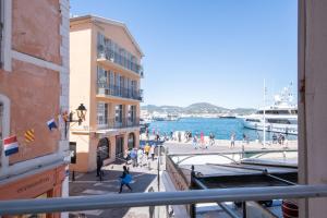 a group of people walking on a sidewalk next to the water at RARE! Appartement, 100m2, Climatisé - Port de Saint-Tropez in Saint-Tropez