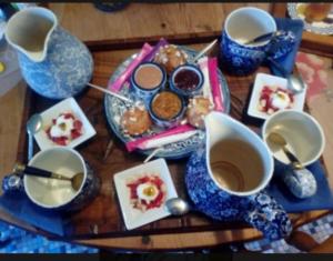 a table with cups and plates of food and coffee at Abrigermaine in Arromanches-les-Bains