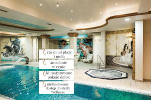 a room with a swimming pool and paintings on the walls at Trofana Wellness & SPA in Międzyzdroje