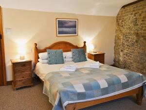 A bed or beds in a room at Flint Barn 