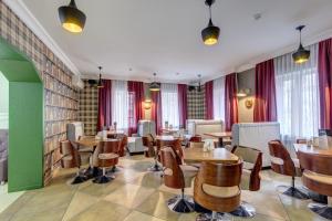 a restaurant with wooden tables and chairs and windows at Well Sleep Hotel in Almaty