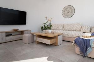 a living room with a couch and a tv at Naxian sun apartment in Naxos Chora