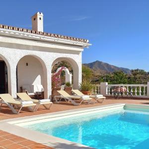 uma piscina com espreguiçadeiras e uma casa em Romantic white Villa -private pool em Nerja