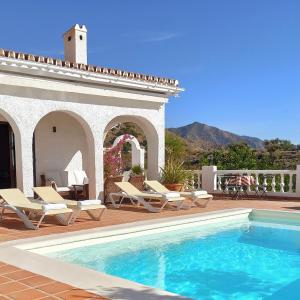 Una piscina con tumbonas y una casa. en Romantic white Villa -private pool, en Nerja