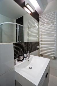 La salle de bains est pourvue d'un lavabo blanc et d'un miroir. dans l'établissement Jagiellońska 34, à Zakopane