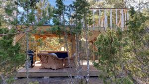 a house with a gazebo in the middle of trees at Üügumetsa treehouse and sauna in Kallaste