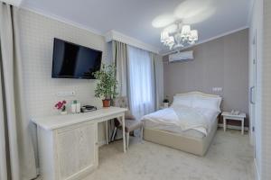 une chambre avec un lit, un bureau et une télévision dans l'établissement Well Sleep Hotel, à Almaty 34 autres photos