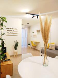 a living room with a white table with a vase of grass at NUEVA CORDOBA Apartamento ILLIA, Excelente ubicación!!! in Córdoba