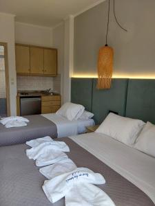 two beds in a hotel room with towels on them at Ninos On The Beach Hotel in Roda
