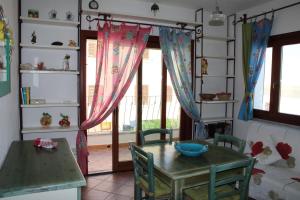 une cuisine avec une table et des chaises ainsi qu'une fenêtre dans l'établissement Charming flat in Santa Teresa Gallura, à Santa Teresa Gallura