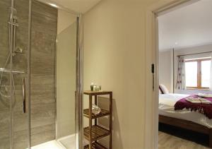 a bathroom with a glass shower and a bed at Partridge in Saint James