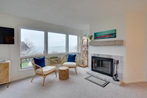 a living room with two chairs and a fireplace at Lakefront Dewittville Condo with Private Deck! in Dewittville