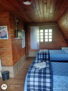 a bedroom with two beds in a wooden cabin at Pousada nossa senhora in Aiuruoca