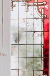 una ventana de cristal con un objeto rojo detrás. en Maison Jullian, en Béziers