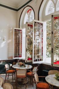 a restaurant with tables and chairs and stained glass windows at Maison Jullian in Béziers