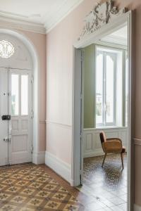 a hallway with a chair and an open door at Maison Jullian in Béziers