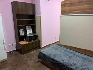 a bedroom with a bed and a microwave in it at Like Home Guest Rooms in Sofia