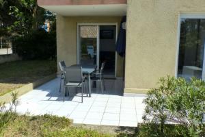 eine Terrasse mit einem Tisch und Stühlen vor einem Haus in der Unterkunft Nice 33 m apartment with garden and terrace in Six-Fours-les-Plages