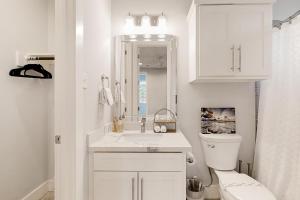 a white bathroom with a toilet and a sink at Houston's Hidden Wonder in Houston