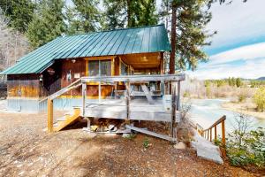 een kleine houten hut met een groen dak bij North Fork Cabin in Cle Elum