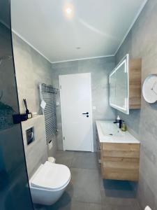 Łazienka z białą toaletą i umywalką w obiekcie Easy Stay w Keflavíku
