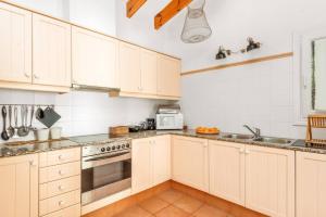 a kitchen with white cabinets and stainless steel appliances at Sa Figuera de Moru in Trebeluger