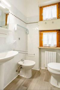 Baño blanco con aseo y lavamanos en B&B Le Palme, en Grottammare