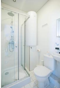 a bathroom with a shower and a toilet and a sink at Rooms and Suites at Bookinn B&B in Vilnius