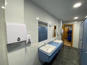 a bathroom with two sinks and a mirror at Albergue El Camino de Santovenia in Santovenia de Oca