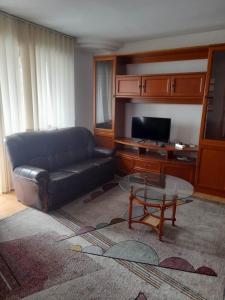 een woonkamer met een leren bank en een salontafel bij Spacious 4 rooms downtown apartment in Pitesti in Piteşti