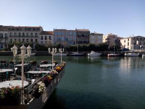 uma marina com mesas e barcos na água em mobil home 001 em Agde