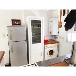 a kitchen with a refrigerator and a washing machine at Departamento amplio, cochera incluida, zona centro in Rosario