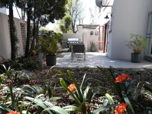un patio con mesa, sillas y plantas en Villa in the Village, en Johannesburgo