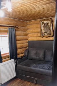 sala de estar con sofá en una habitación con paredes de madera en Котедж в Карпатах en Huklyvyy