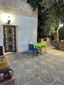 a green table and chairs sitting on a patio at Elegant housing in Jerash
