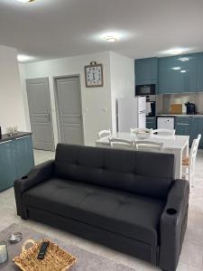 un soggiorno con divano nero in cucina di HARMONIE a Le Grau-dʼAgde