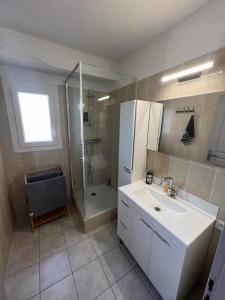 bagno con lavandino bianco e doccia di HARMONIE a Le Grau-dʼAgde